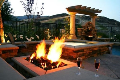Mid-sized trendy backyard stamped concrete patio photo in Los Angeles with a fire pit and a pergola