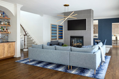 Living room - huge transitional open concept medium tone wood floor living room idea in Newark with a bar, white walls, a two-sided fireplace, a tile fireplace and a wall-mounted tv