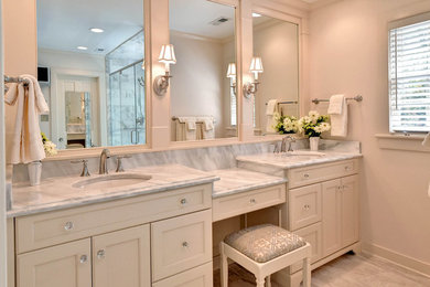 Mid-sized traditional master bathroom in Other with marble floors, marble benchtops, beige tile, beige walls, an undermount sink, recessed-panel cabinets and beige cabinets.