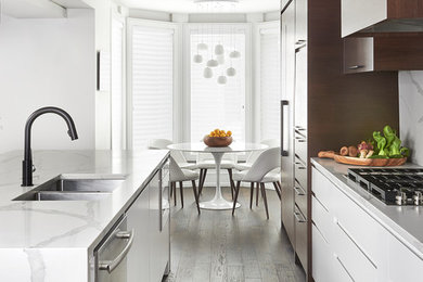Inspiration for an expansive contemporary galley open plan kitchen in Toronto with an undermount sink, flat-panel cabinets, dark wood cabinets, quartz benchtops, white splashback, stone slab splashback, panelled appliances, dark hardwood floors, with island and white benchtop.