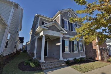 Example of a small arts and crafts beige two-story concrete fiberboard exterior home design in Other with a clipped gable roof