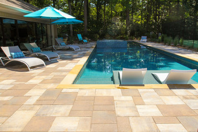 Inspiration for a large arts and crafts side yard rectangular lap pool in Other with a pool house and natural stone pavers.