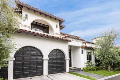 Large transitional beige two-story concrete house exterior idea in Los Angeles with a hip roof and a tile roof