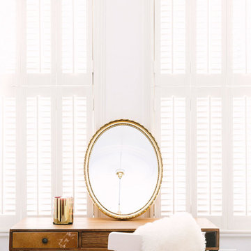 A rustic bedroom with a touch of blush and brass