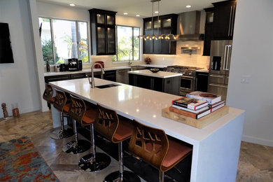 Mid-Century Küche in L-Form mit Landhausspüle, Schrankfronten im Shaker-Stil, schwarzen Schränken, Quarzwerkstein-Arbeitsplatte, Küchenrückwand in Weiß, Rückwand aus Zementfliesen, Küchengeräten aus Edelstahl, Kalkstein, zwei Kücheninseln und weißer Arbeitsplatte in San Diego
