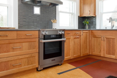 Enclosed kitchen - small eclectic u-shaped multicolored floor enclosed kitchen idea in Portland with an undermount sink, shaker cabinets, medium tone wood cabinets, quartz countertops, gray backsplash, glass tile backsplash, stainless steel appliances, an island and gray countertops