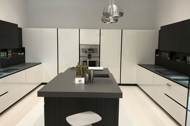 Mid-sized minimalist u-shaped kitchen photo in New York with an undermount sink, white cabinets, quartzite countertops, an island and black countertops