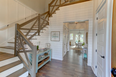 Inspiration for a large contemporary medium tone wood floor and brown floor foyer remodel in Charleston with white walls