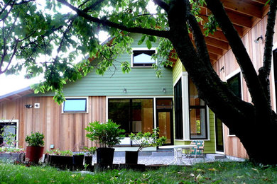 Inspiration for a mid-sized contemporary two-storey green exterior in Seattle with concrete fiberboard siding and a gable roof.
