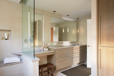 Photo of a mid-sized contemporary master bathroom with flat-panel cabinets, concrete benchtops, light wood cabinets, an open shower, beige tile, porcelain tile, beige walls, porcelain floors, a trough sink, beige floor and an open shower.