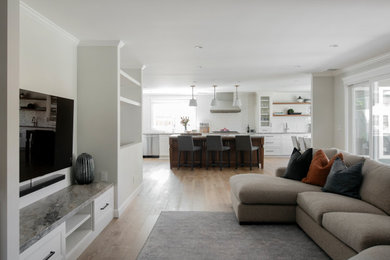 Inspiration for a large craftsman l-shaped light wood floor open concept kitchen remodel in San Francisco with an undermount sink, recessed-panel cabinets, white cabinets, quartzite countertops, white backsplash, porcelain backsplash, stainless steel appliances and an island