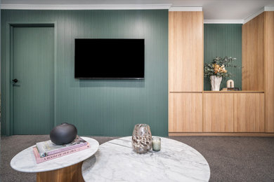 Photo of a mid-sized enclosed family room in Melbourne with green walls, carpet, a wall-mounted tv, grey floor and decorative wall panelling.