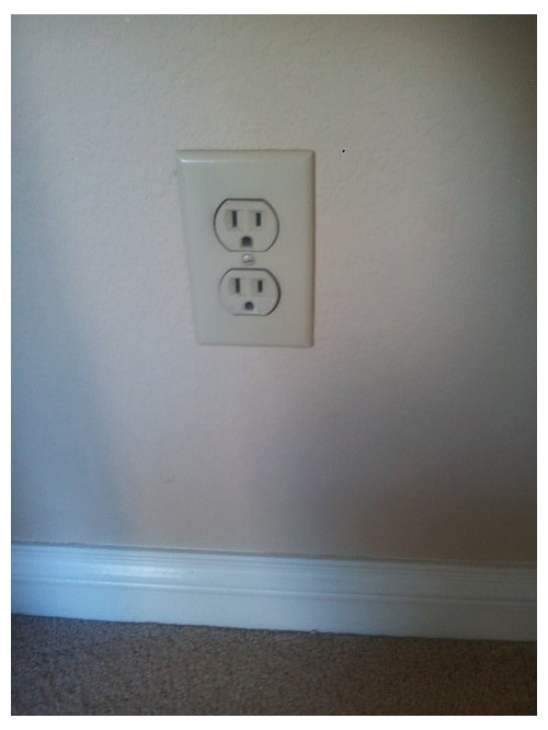 White electrical switches on almond painted walls