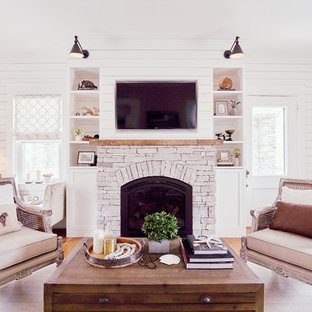 Esempio di un grande soggiorno shabby-chic style aperto con pareti bianche, pavimento in legno massello medio, stufa a legna, cornice del camino in pietra, parete attrezzata e pavimento beige
