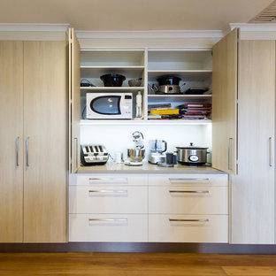 Large modern kitchen pantry designs - Inspiration for a large modern u-shaped medium tone wood floor and brown floor kitchen pantry remodel in Melbourne with a drop-in sink, flat-panel cabinets, white cabinets, quartz countertops, gray backsplash, glass sheet backsplash, stainless steel appliances and an island