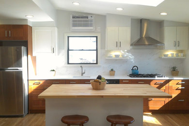 Open concept kitchen - mid-sized modern galley light wood floor open concept kitchen idea in New York with an undermount sink, recessed-panel cabinets, medium tone wood cabinets, white backsplash, stainless steel appliances, an island, quartz countertops and marble backsplash