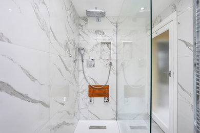Photo of a small contemporary kids bathroom in London with flat-panel cabinets, white cabinets, an open shower, a wall-mount toilet, white tile, ceramic tile, white walls, cement tiles, a wall-mount sink, grey floor and an open shower.