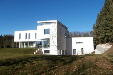 Geräumiges Modernes Haus mit Putzfassade, weißer Fassadenfarbe und Flachdach