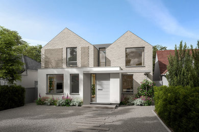 This is an example of a large and gey contemporary two floor brick and front detached house in London with a pitched roof, a tiled roof and a grey roof.