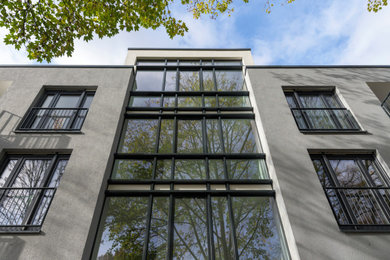 Mittelgroßes, Vierstöckiges Klassisches Haus mit Putzfassade, grauer Fassadenfarbe und Flachdach in Düsseldorf