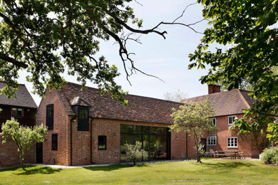 Inspiration for an expansive and red contemporary two floor brick and rear house exterior in Hampshire with a pitched roof, a tiled roof and a red roof.