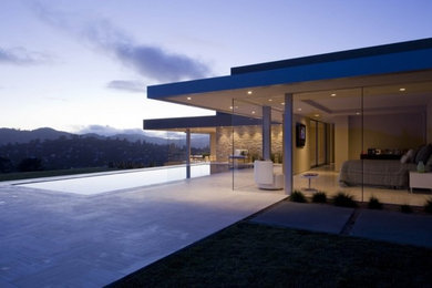 Contemporary hillside home with marble tile floor and vanishing edge pool.