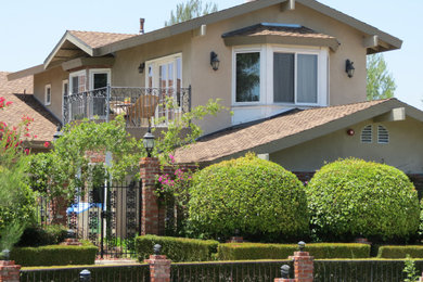 Large two-story stucco exterior home idea in Orange County with a tile roof