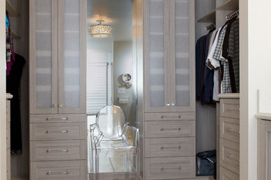 This is an example of a small modern women's walk-in wardrobe in Sacramento with recessed-panel cabinets, grey cabinets and porcelain floors.