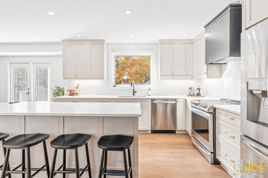 Huge 1950s l-shaped light wood floor and brown floor eat-in kitchen photo in Other with a double-bowl sink, shaker cabinets, gray cabinets, quartzite countertops, white backsplash, ceramic backsplash, stainless steel appliances, an island and white countertops
