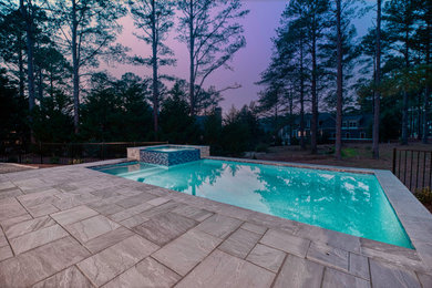 Mid-sized backyard stone and rectangular infinity hot tub photo in Atlanta