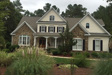 Large traditional two-storey white house exterior in Raleigh with stone veneer.