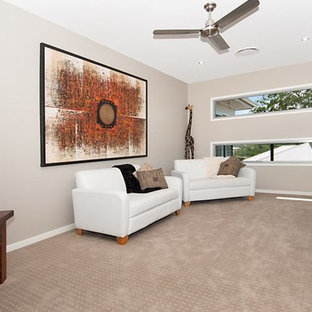 Mid-sized asian enclosed carpeted home theater photo in Sunshine Coast with beige walls and a wall-mounted tv