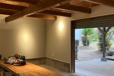 他の地域にある小さな和モダンなおしゃれなリビング (ベージュの壁、コンクリートの床、グレーの床、表し梁、塗装板張りの壁) の写真