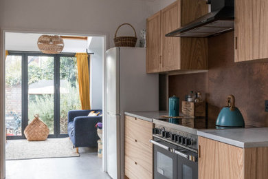Inspiration for a small retro kitchen in Other with a belfast sink, flat-panel cabinets, medium wood cabinets, quartz worktops, metallic splashback, concrete flooring and grey worktops.