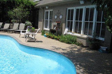 Example of a mid-sized classic backyard decomposed granite and custom-shaped pool design in Other