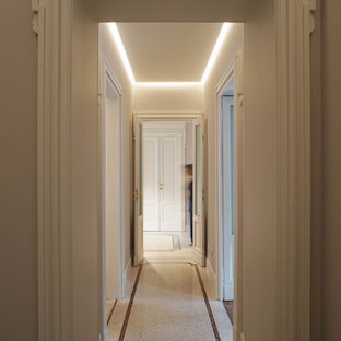 Klassisk inredning av en mycket stor hall, med grå väggar, terrazzogolv och beiget golv