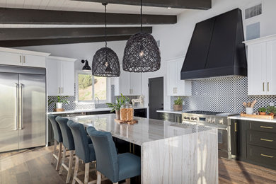 Example of a huge l-shaped medium tone wood floor and brown floor kitchen design in Houston with an undermount sink, shaker cabinets, black cabinets, multicolored backsplash, stainless steel appliances, an island and white countertops