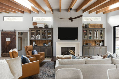 Example of a mid-sized farmhouse formal and open concept medium tone wood floor living room design in Los Angeles with white walls, a standard fireplace, a concrete fireplace and a wall-mounted tv