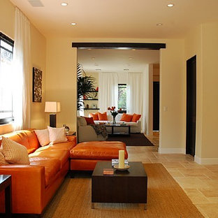 This is an example of a medium sized contemporary open plan home cinema in Los Angeles with beige walls, limestone flooring and a wall mounted tv.
