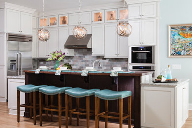 Eat-in kitchen - traditional light wood floor eat-in kitchen idea in Wilmington with white cabinets, wood countertops, gray backsplash, stone tile backsplash, stainless steel appliances and an island