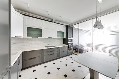 Mid-sized transitional l-shaped eat-in kitchen in Other with an undermount sink, recessed-panel cabinets, grey cabinets, solid surface benchtops, ceramic splashback, stainless steel appliances, ceramic floors, no island, white floor and white benchtop.
