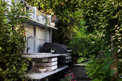 Example of a minimalist backyard concrete patio kitchen design in Los Angeles