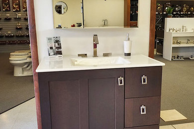 Cette photo montre une salle de bain moderne en bois foncé avec un plan de toilette blanc.