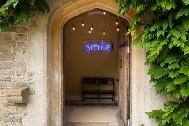 Photo of a traditional front door in Wiltshire with a single front door, a dark wood front door and yellow walls.