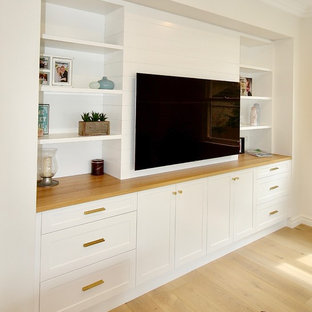 This is an example of a large classic enclosed home cinema in Sydney with white walls, medium hardwood flooring, a wall mounted tv and brown floors.