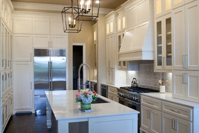 Inspiration for a large transitional u-shaped dark wood floor open concept kitchen remodel in Dallas with an undermount sink, glass-front cabinets, white cabinets, quartz countertops, white backsplash, stone tile backsplash, stainless steel appliances and an island