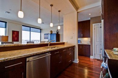 Open concept kitchen - small transitional galley dark wood floor open concept kitchen idea in Toronto with a double-bowl sink, flat-panel cabinets, dark wood cabinets, granite countertops and stainless steel appliances