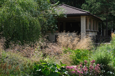 На фото: летний участок и сад на внутреннем дворе с клумбами с