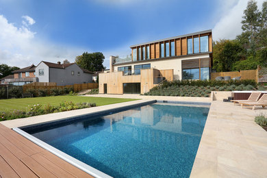 Photo of a large contemporary backyard rectangular aboveground pool in Buckinghamshire with tile.