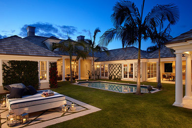 Design ideas for a mid-sized traditional courtyard patio in Miami with stamped concrete and a roof extension.